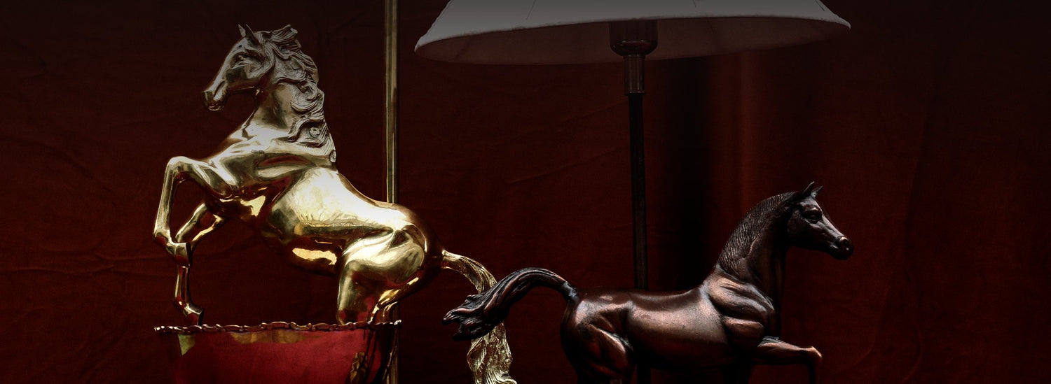 Brass and copper horse table lamps in moody light